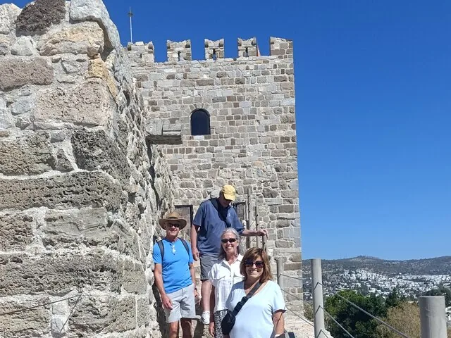 Touristen auf einer Steintreppe nahe einem hohen Turm der Burg von Bodrum