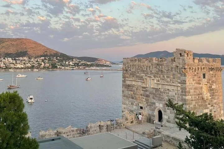 Blick auf einen Steinturm der Burg von Bodrum mit Blick auf das Meer bei Sonnenuntergang