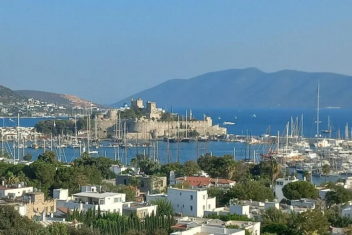 Malerischer Blick auf die Burg von Bodrum, umgeben von blauem Wasser und Booten im Yachthafen