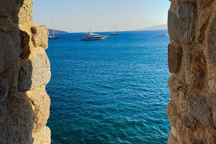 View of yachts in the blue sea framed by rough stone walls