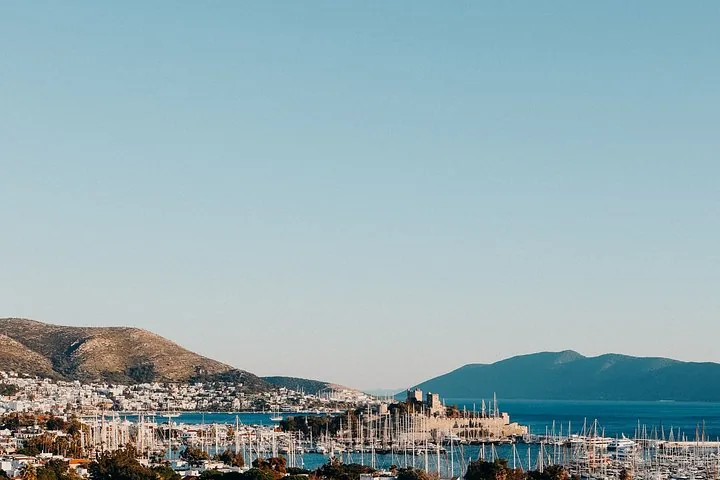 Panoramic view of Bodrum Castle, marina, and coastal hills under a clear blue sky