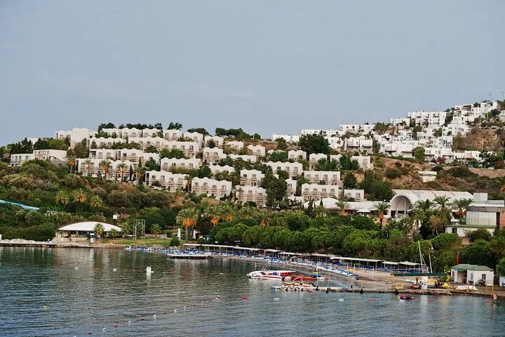 Weiße Resortgebäude am Hang mit Blick auf das ruhige Meer in Bodrum